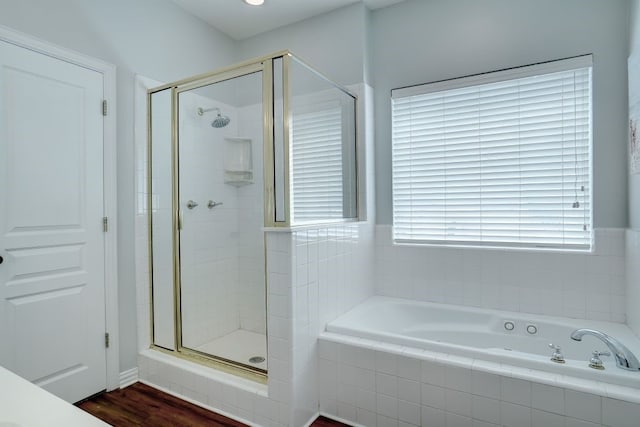 bathroom with shower with separate bathtub and hardwood / wood-style flooring