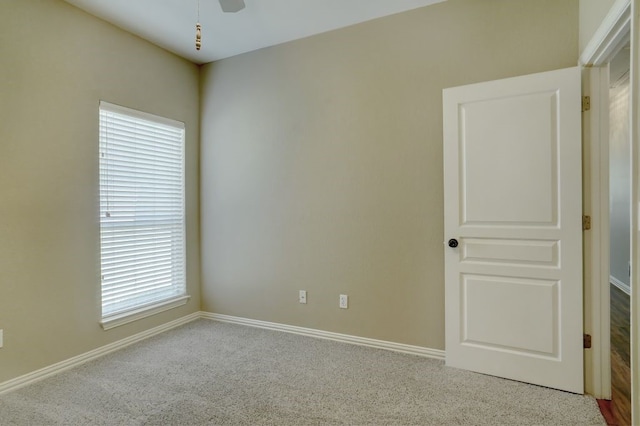 carpeted empty room with a healthy amount of sunlight and ceiling fan