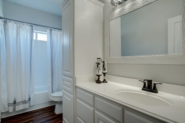 full bathroom with hardwood / wood-style flooring, shower / tub combo, toilet, and vanity