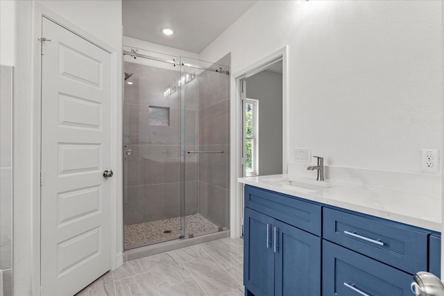 bathroom with a shower with door and vanity