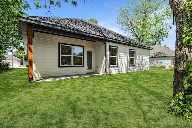 rear view of property featuring a yard