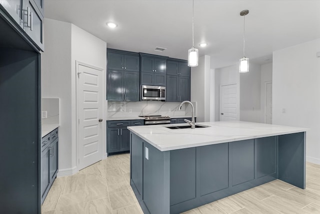 kitchen with a kitchen island with sink, decorative light fixtures, sink, light stone counters, and stainless steel appliances