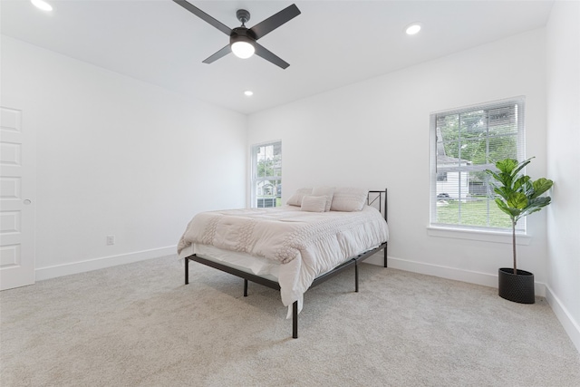 carpeted bedroom with ceiling fan and multiple windows