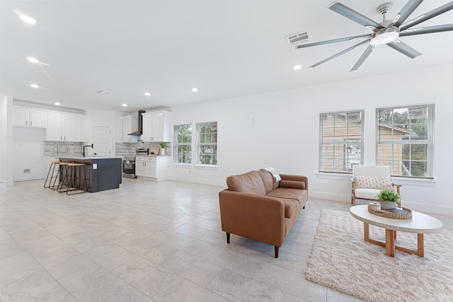 living room featuring sink, ceiling fan, and light tile flooring