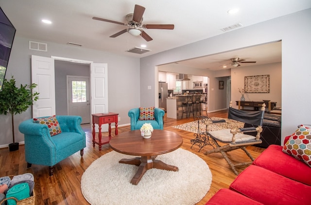 living room featuring wood-type flooring and ceiling fan