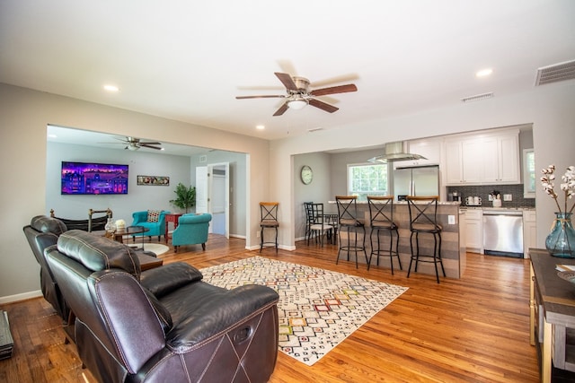 living room featuring light hardwood / wood-style floors and ceiling fan