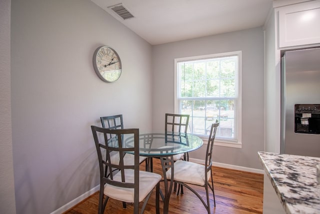 dining area featuring dark wood-type flooring and lofted ceiling