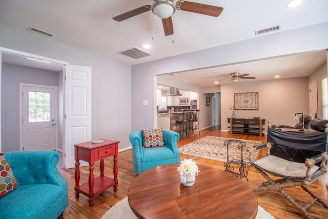 living room with wood-type flooring and ceiling fan