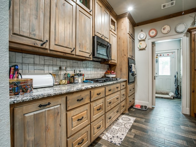 kitchen with light stone counters, backsplash, dark hardwood / wood-style flooring, stainless steel appliances, and ornamental molding