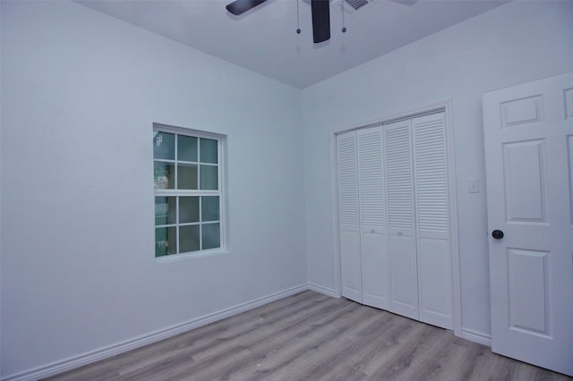 unfurnished bedroom with a closet, light hardwood / wood-style floors, and ceiling fan