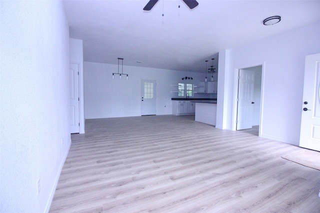 unfurnished living room with light wood-type flooring and ceiling fan