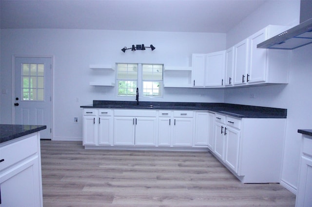 kitchen with white cabinets, plenty of natural light, light hardwood / wood-style floors, and range hood