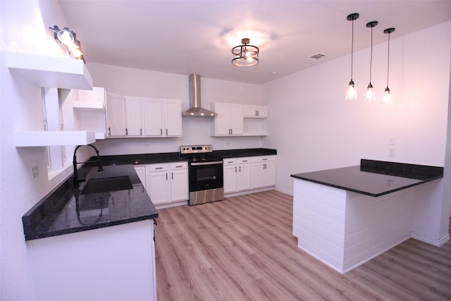 kitchen featuring sink, white cabinetry, wall chimney exhaust hood, stainless steel electric stove, and decorative light fixtures