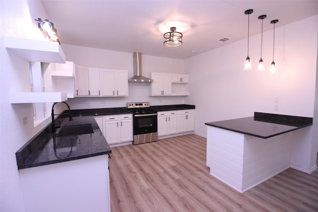 kitchen featuring stainless steel electric range oven, decorative light fixtures, sink, white cabinets, and wall chimney range hood