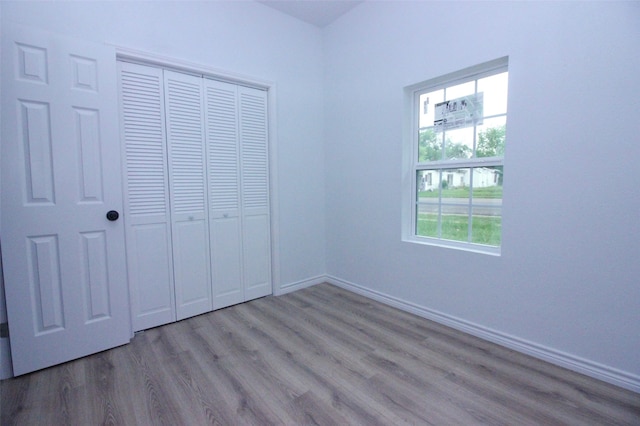 unfurnished bedroom featuring light hardwood / wood-style floors and a closet