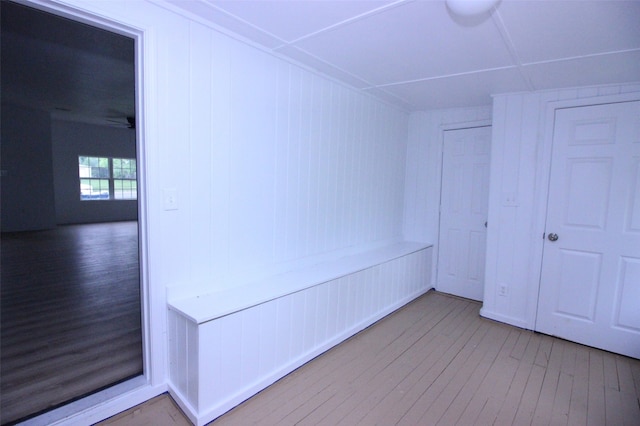 interior space with wooden walls, ceiling fan, and hardwood / wood-style flooring