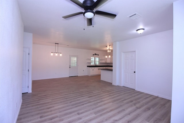 unfurnished living room with ceiling fan and light hardwood / wood-style flooring