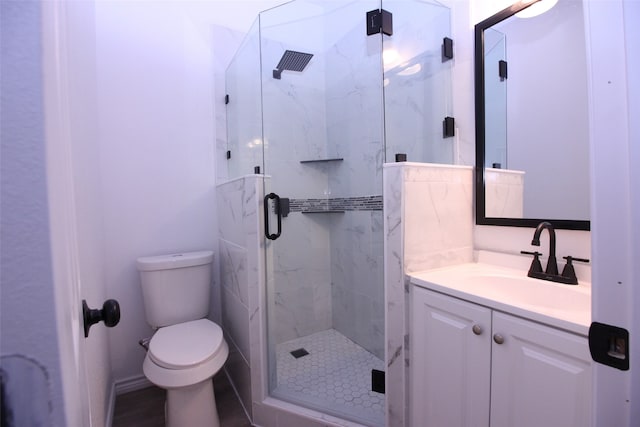 bathroom with vanity, toilet, and a shower with door