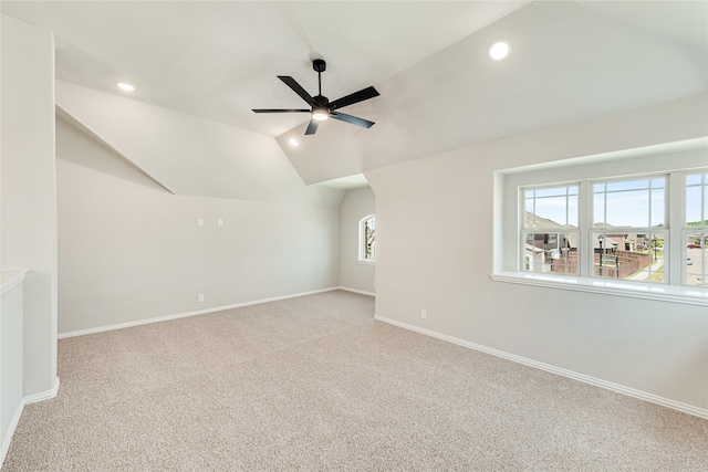 interior space with a wealth of natural light, ceiling fan, vaulted ceiling, and light carpet