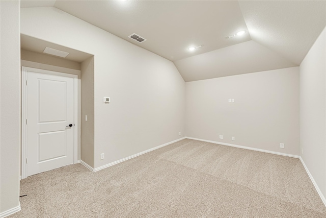 unfurnished room featuring lofted ceiling and light colored carpet