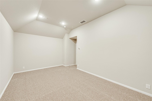 unfurnished room with carpet flooring and vaulted ceiling