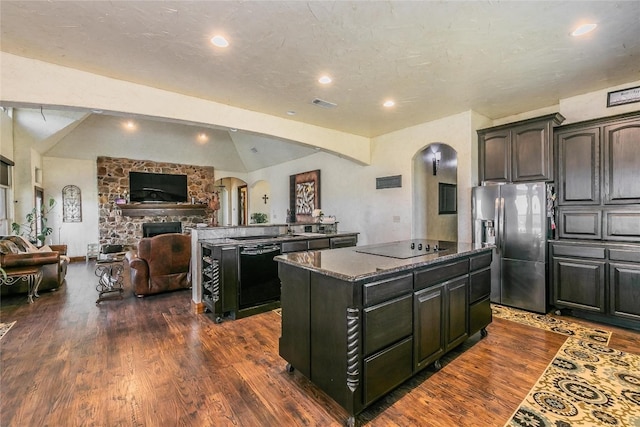 kitchen with a center island, a fireplace, lofted ceiling with beams, dark hardwood / wood-style flooring, and black appliances