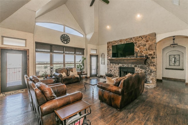 living room featuring ceiling fan, a fireplace, high vaulted ceiling, and dark hardwood / wood-style flooring