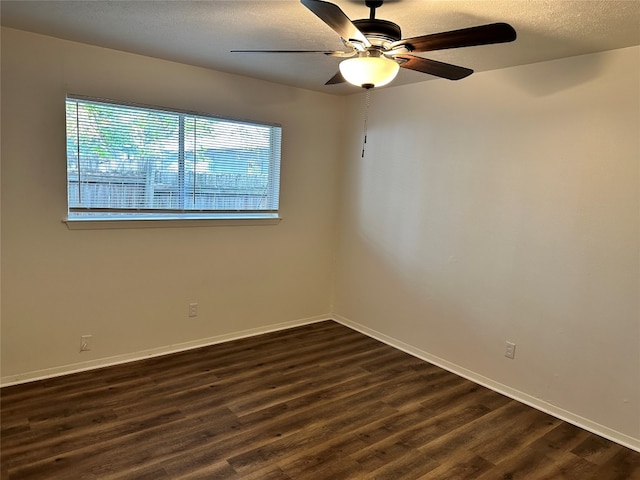 empty room featuring a textured ceiling, ceiling fan, and dark wood-type flooring