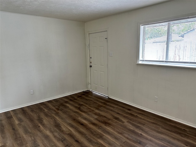 unfurnished room featuring dark hardwood / wood-style floors and a textured ceiling