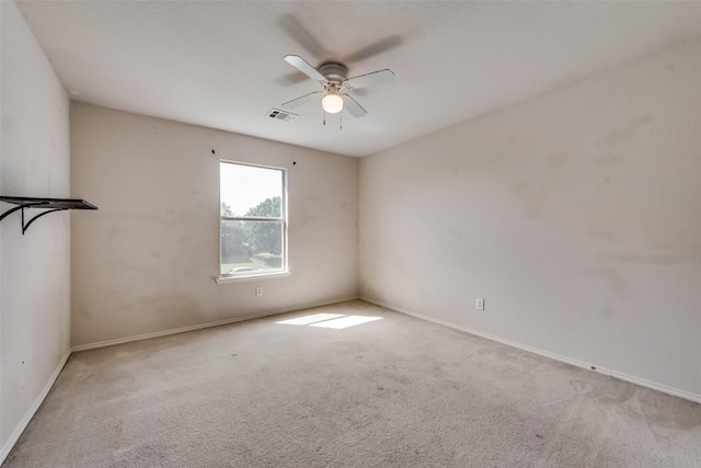 unfurnished room with baseboards, carpet, visible vents, and a ceiling fan