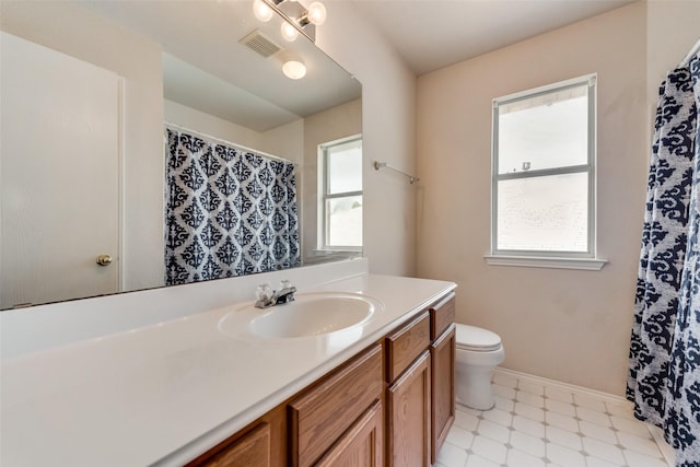 full bathroom featuring toilet, tile patterned floors, visible vents, and a healthy amount of sunlight