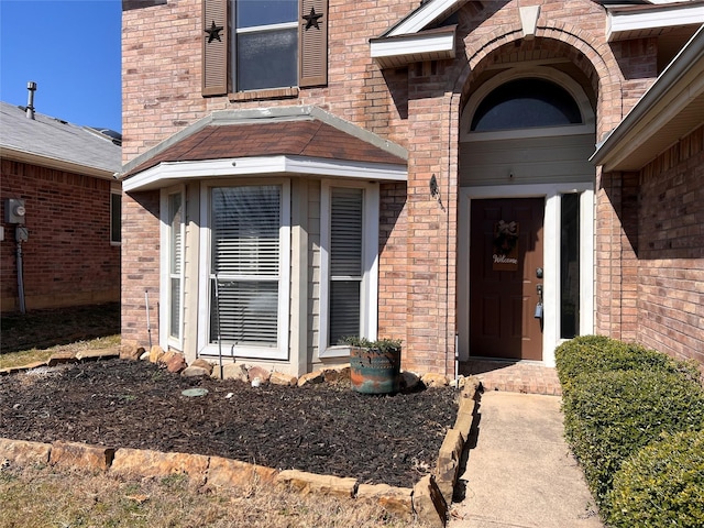 view of front of home with a front yard, concrete driveway, brick siding, and an attached garage