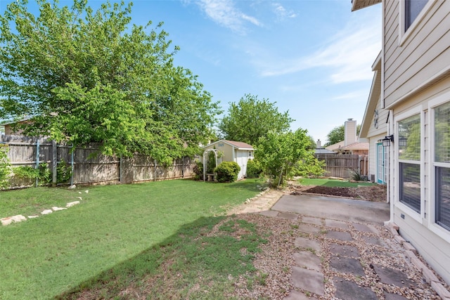 view of yard featuring a patio, an outdoor structure, and a fenced backyard