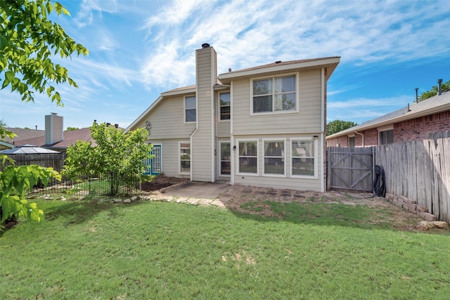 back of property featuring a patio, a fenced backyard, a chimney, a gate, and a yard