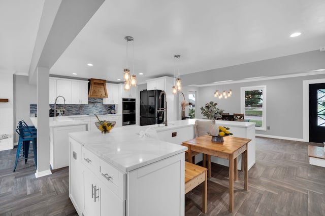 kitchen featuring white cabinetry, decorative light fixtures, dark parquet floors, and black fridge