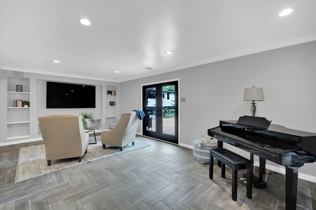 living room featuring parquet floors, built in shelves, ornamental molding, and french doors