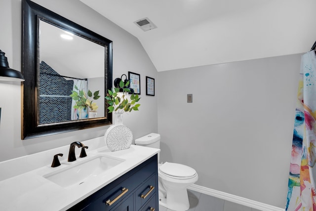 bathroom featuring lofted ceiling, vanity, toilet, and tile patterned flooring