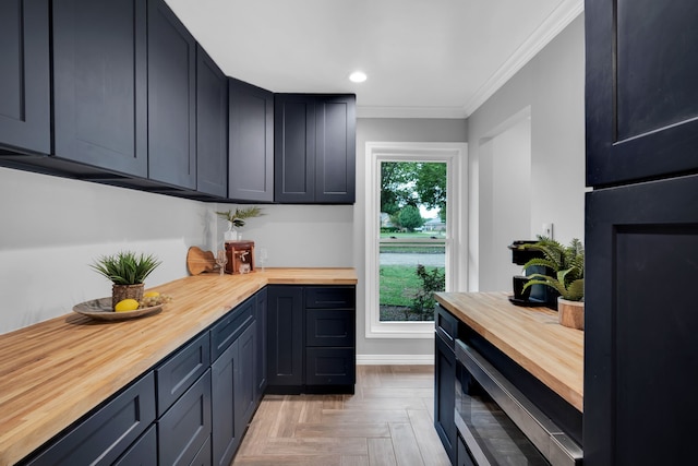 kitchen with butcher block counters, crown molding, a wealth of natural light, and light parquet flooring