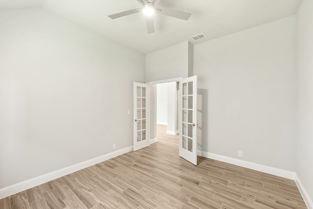 empty room featuring french doors, high vaulted ceiling, light hardwood / wood-style flooring, and ceiling fan