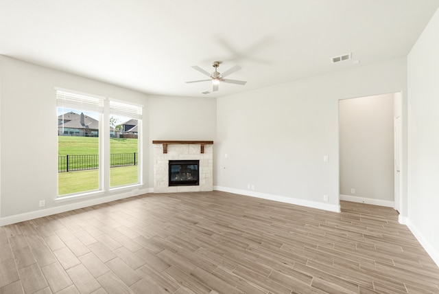 unfurnished living room with light hardwood / wood-style flooring, ceiling fan, and a tile fireplace