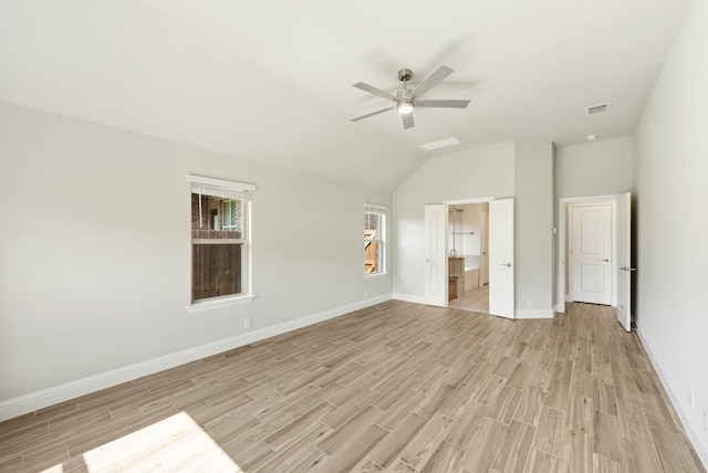 unfurnished bedroom with lofted ceiling, ceiling fan, ensuite bath, and light wood-type flooring