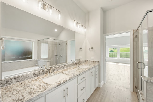 bathroom featuring plus walk in shower, tile patterned floors, lofted ceiling, and vanity