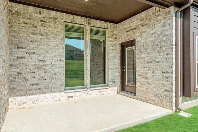 view of exterior entry with a patio area