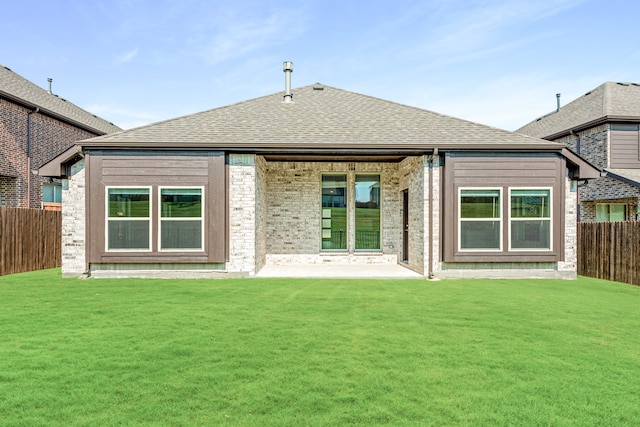 rear view of house with a yard and a patio