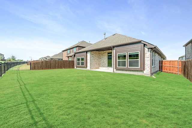 back of house with a lawn and a patio area