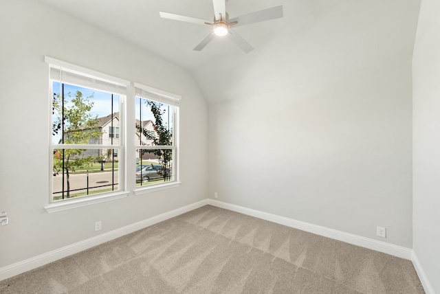 empty room featuring lofted ceiling, ceiling fan, and light carpet