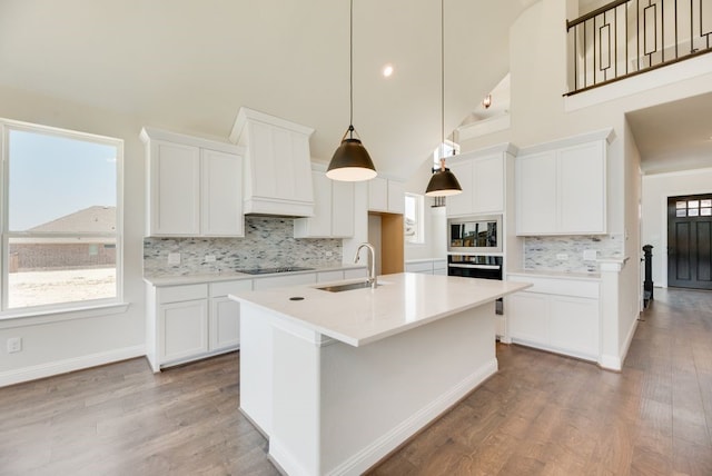 kitchen featuring high vaulted ceiling, white cabinetry, and sink