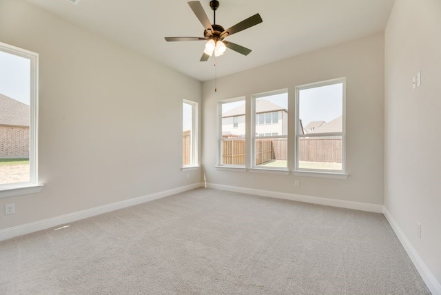 carpeted empty room featuring baseboards and ceiling fan