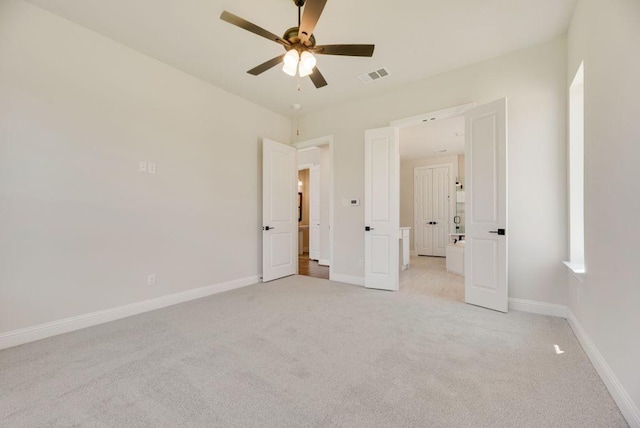 unfurnished bedroom with visible vents, light colored carpet, baseboards, and ceiling fan