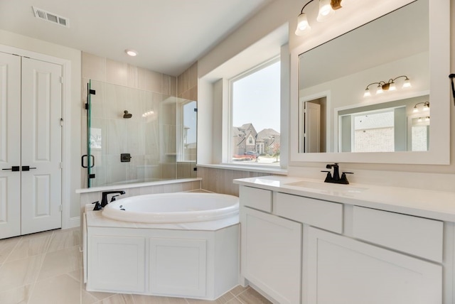 bathroom featuring tile patterned flooring, vanity, a healthy amount of sunlight, and separate shower and tub